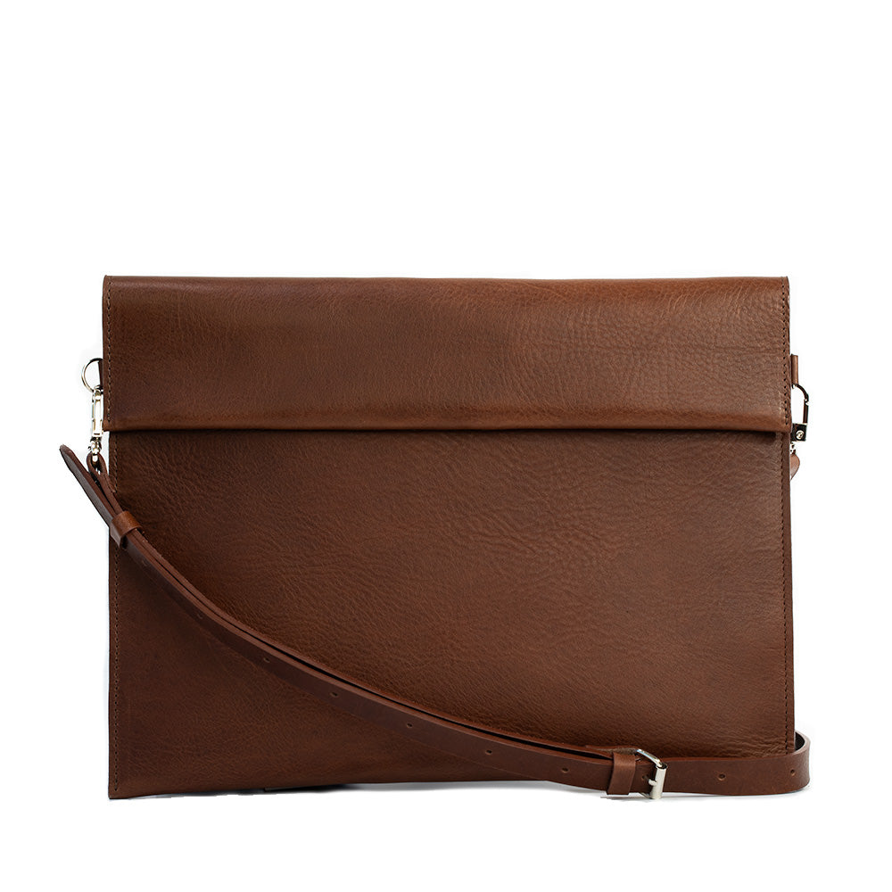 Elegant leather bag designed for iPad, featuring adjustable strap and magnetic closure, showcasing premium craftsmanship.