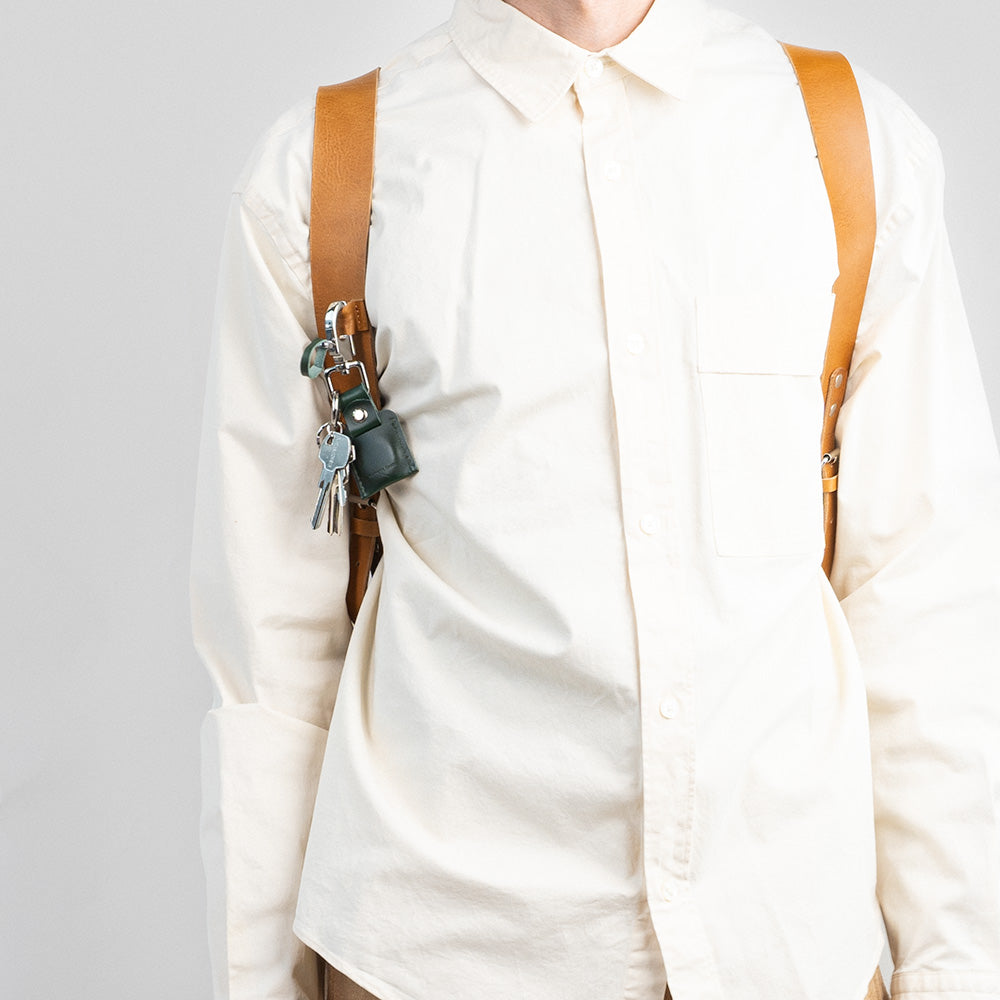 Black leather laptop backpack with adjustable straps and magnetic closure, featuring a sleek design and multiple storage pockets.