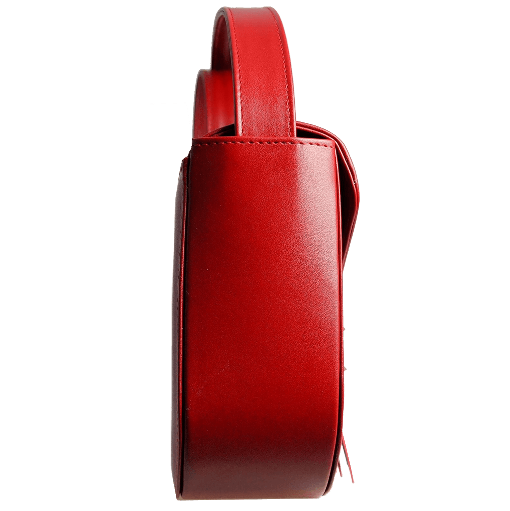 A stylish red leather saddle bag with dovetail fringe clasp, showcasing its luxurious design and spacious interior.