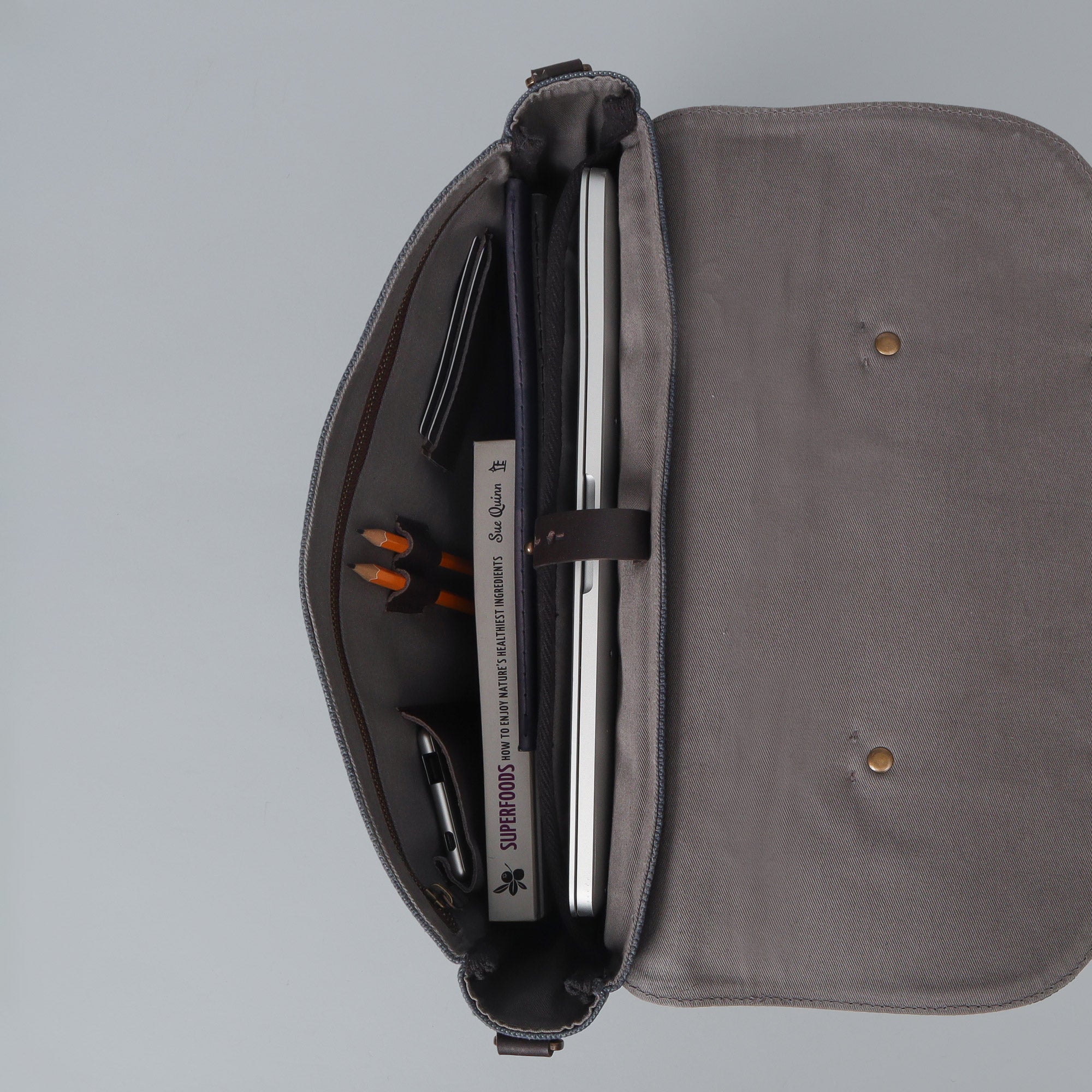 Oslo Canvas Briefcase featuring durable cotton canvas, leather straps, and multiple pockets for organization, ideal for laptops up to 13 inches.