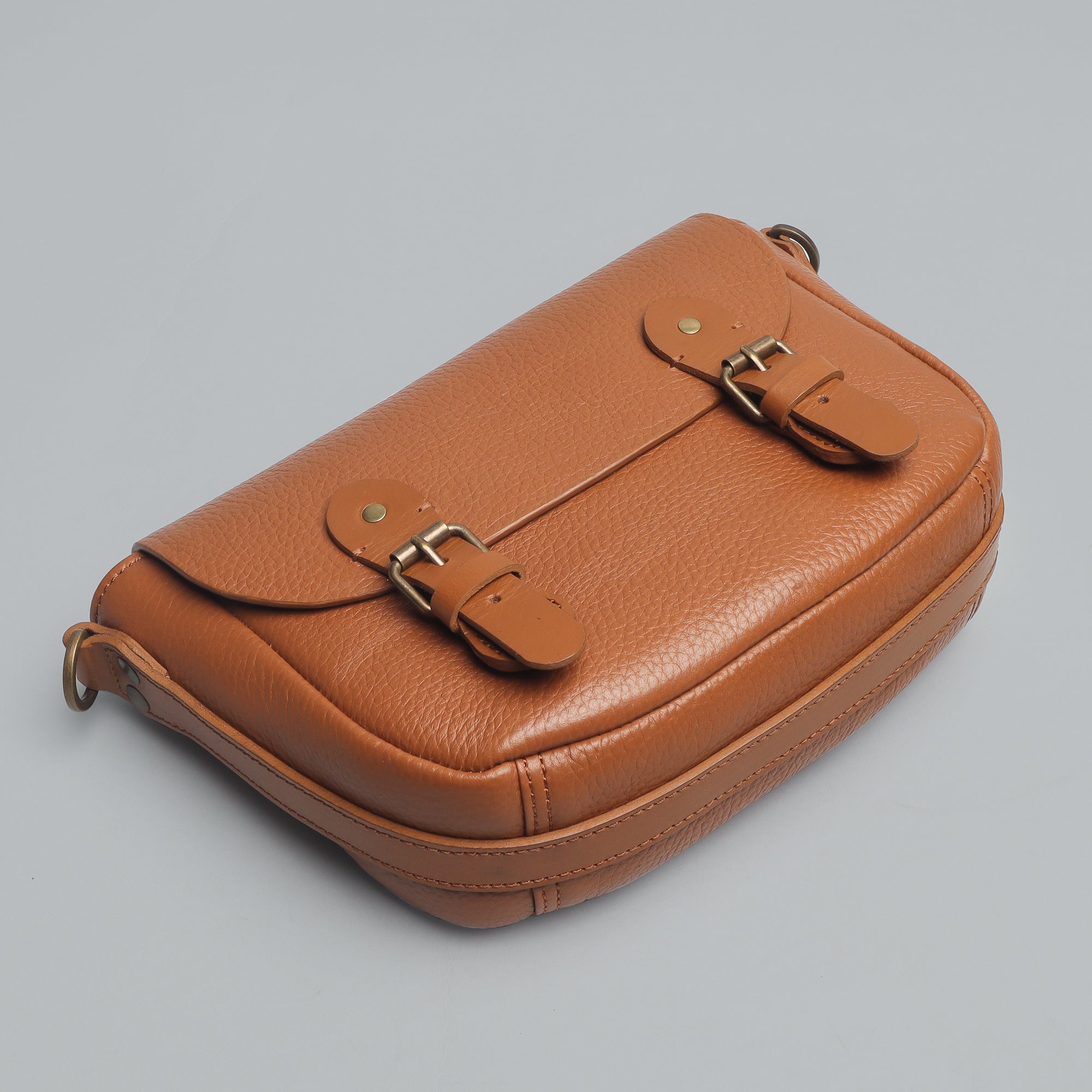 Oslo Crossbody Bag made from premium leather with spacious compartments and antique brass hardware, showcasing its elegant design.