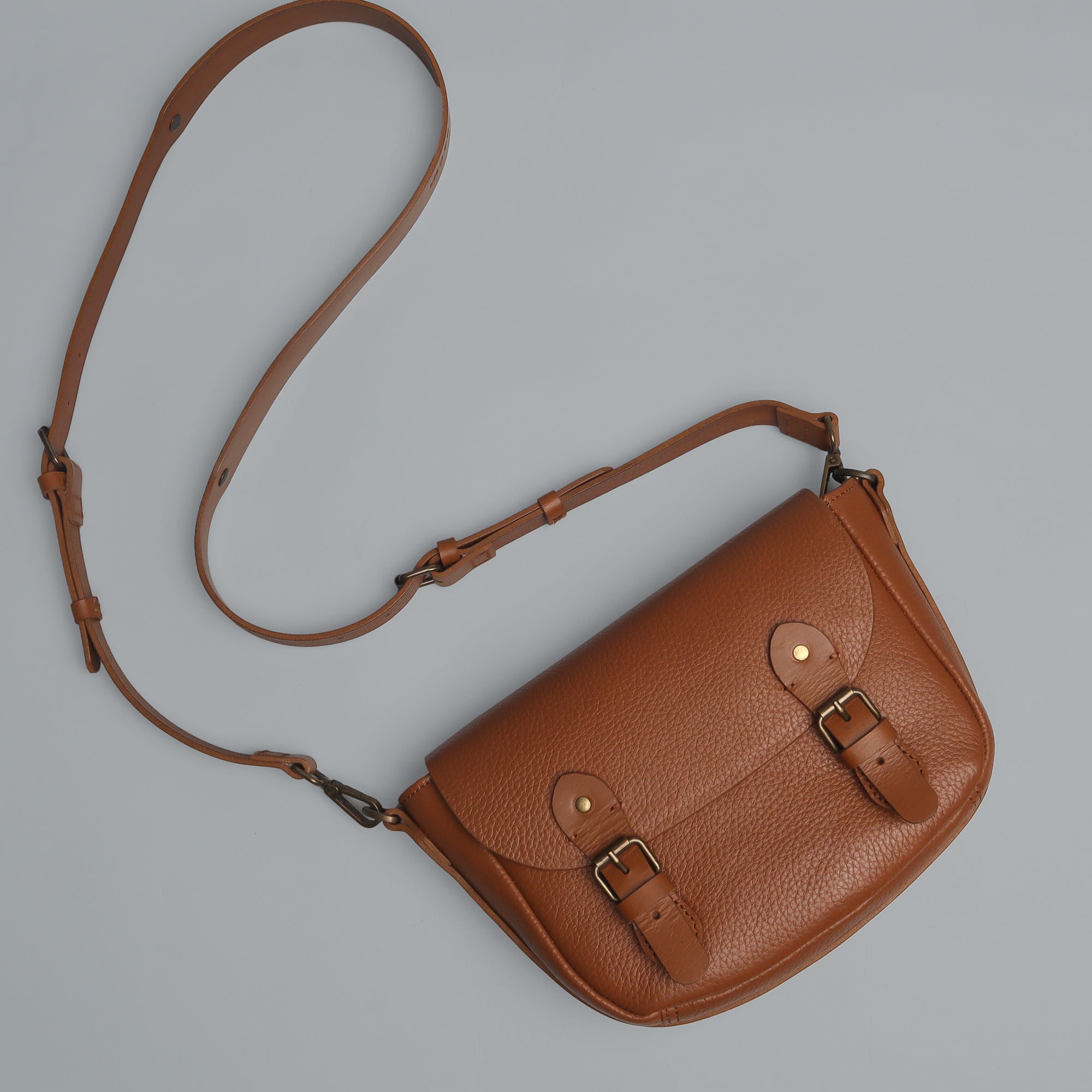 Oslo Crossbody Bag made from premium leather with spacious compartments and antique brass hardware, showcasing its elegant design.