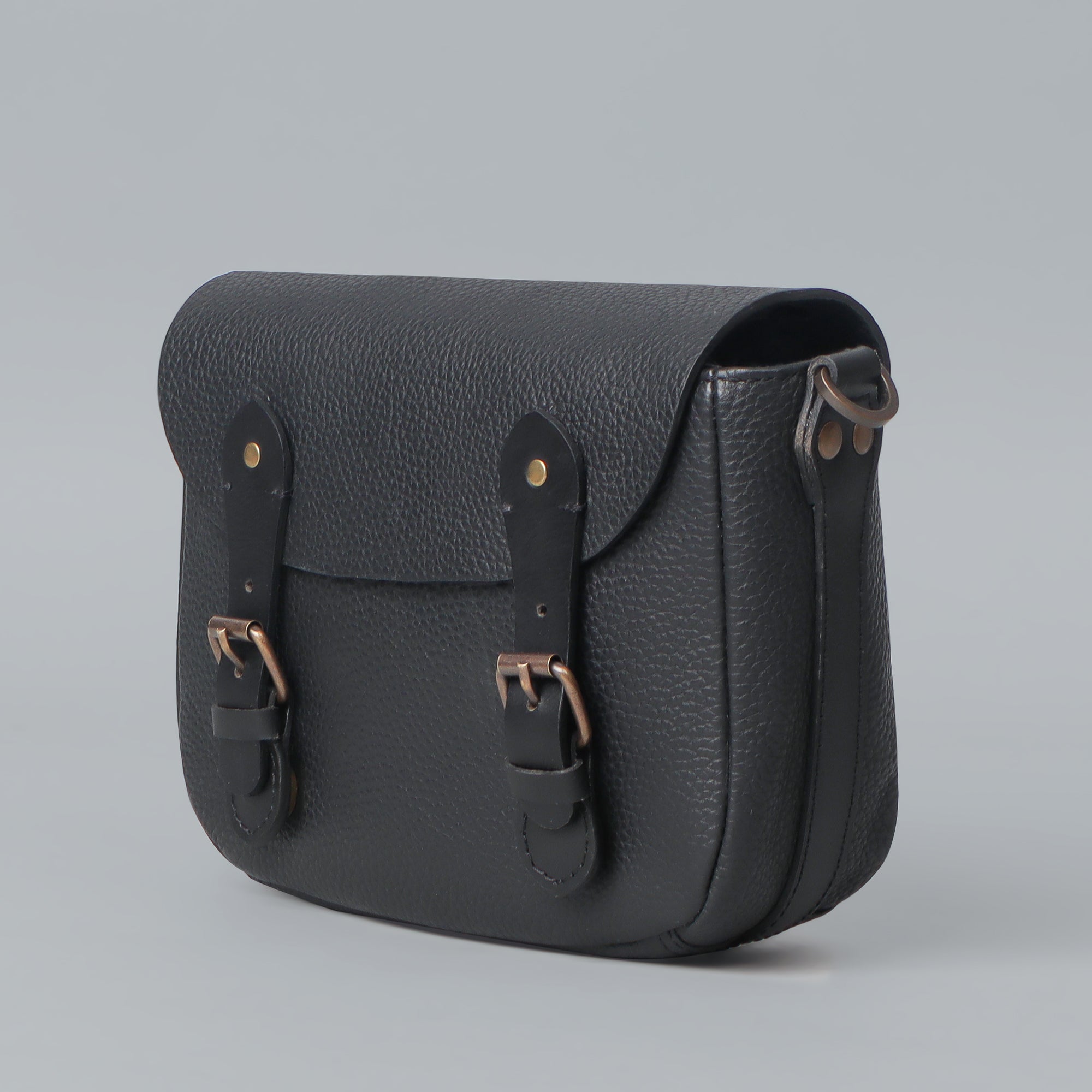 Oslo Crossbody Bag made from premium leather with spacious compartments and antique brass hardware, showcasing its elegant design.