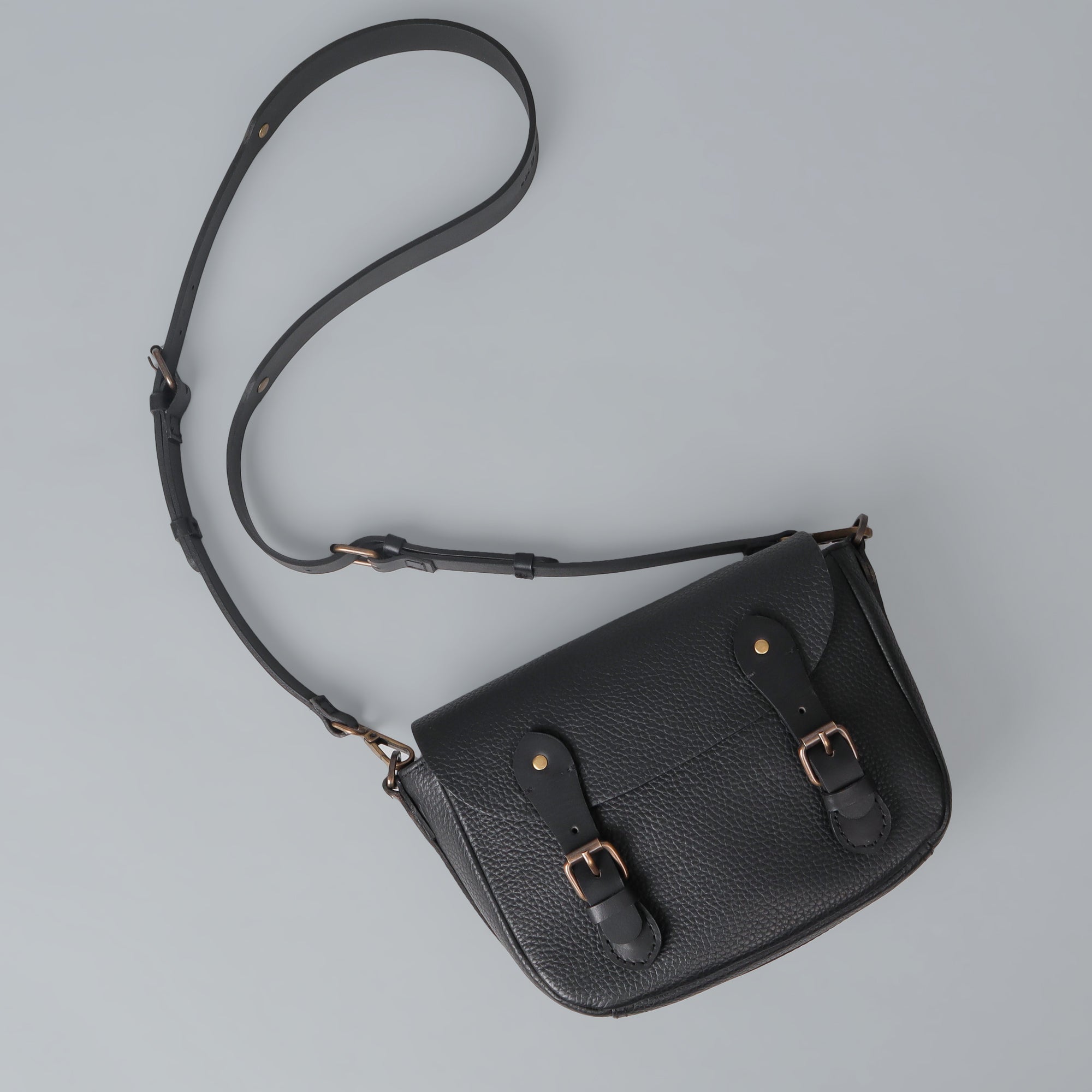 Oslo Crossbody Bag made from premium leather with spacious compartments and antique brass hardware, showcasing its elegant design.