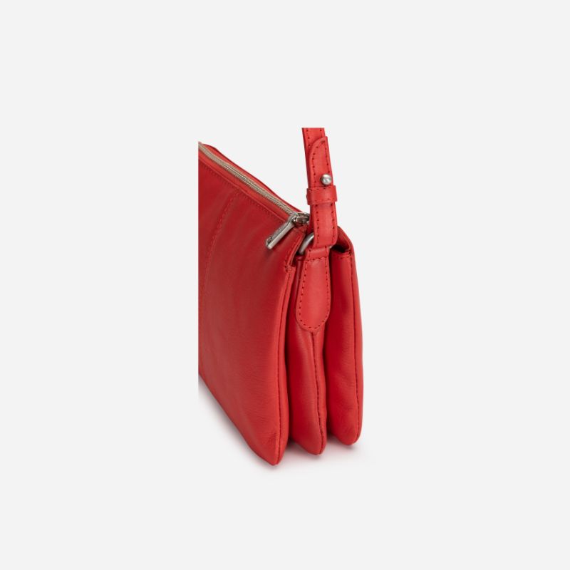 Slim Ladies Leather Crossbody handbag in vibrant candy apple color, showcasing its sleek design and adjustable strap.