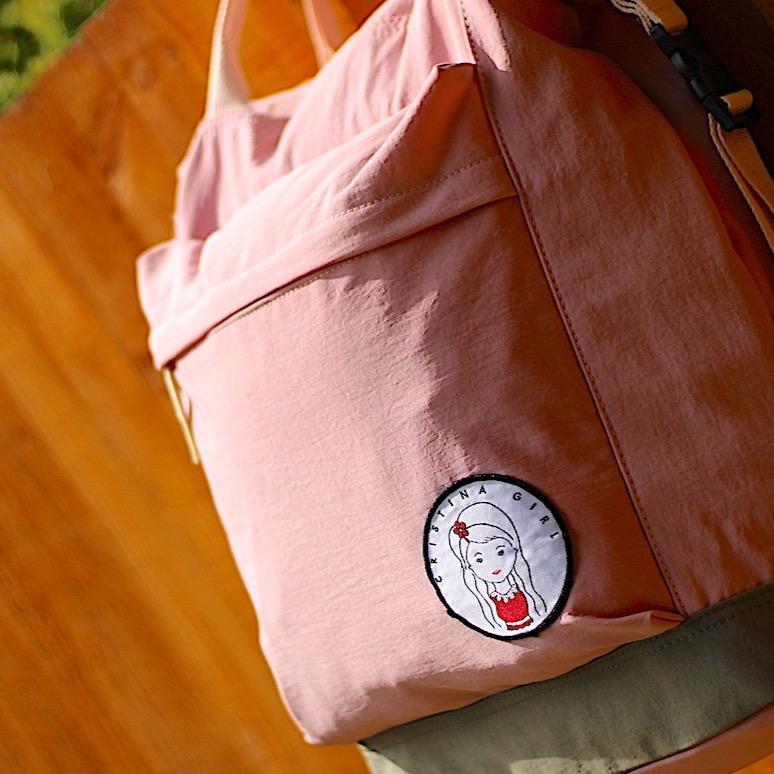 Soft polyester bag and backpack in four colors, featuring adjustable straps and zipped pockets.