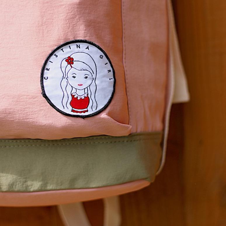 Soft polyester bag and backpack in four colors, featuring adjustable straps and multiple zipped pockets for convenience.