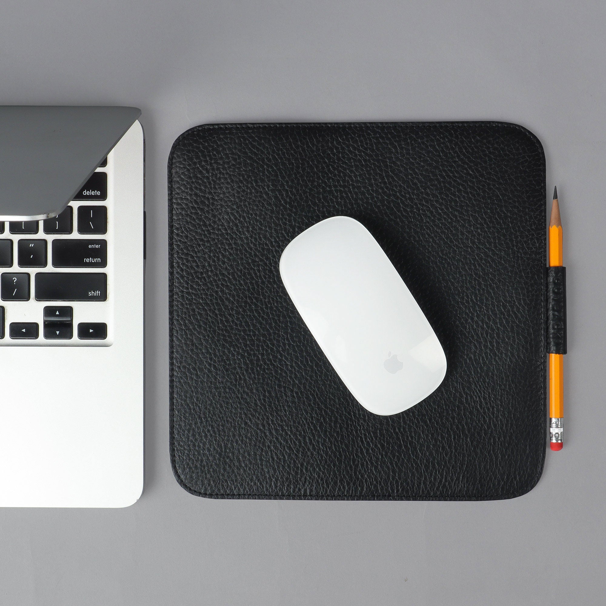 A square mouse pad made from premium full grain leather, featuring a smooth surface and space for a pen or Apple Pencil.