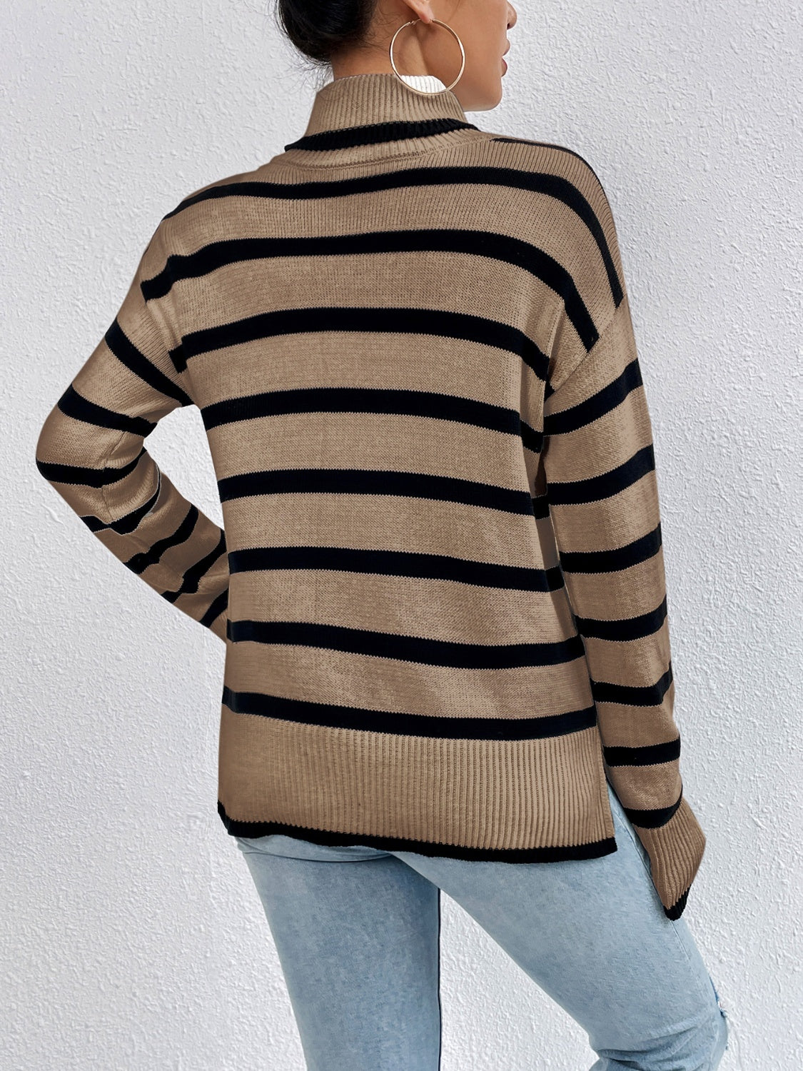 A stylish striped turtleneck drop shoulder sweater in soft fabric, showcasing its relaxed fit and trendy design.