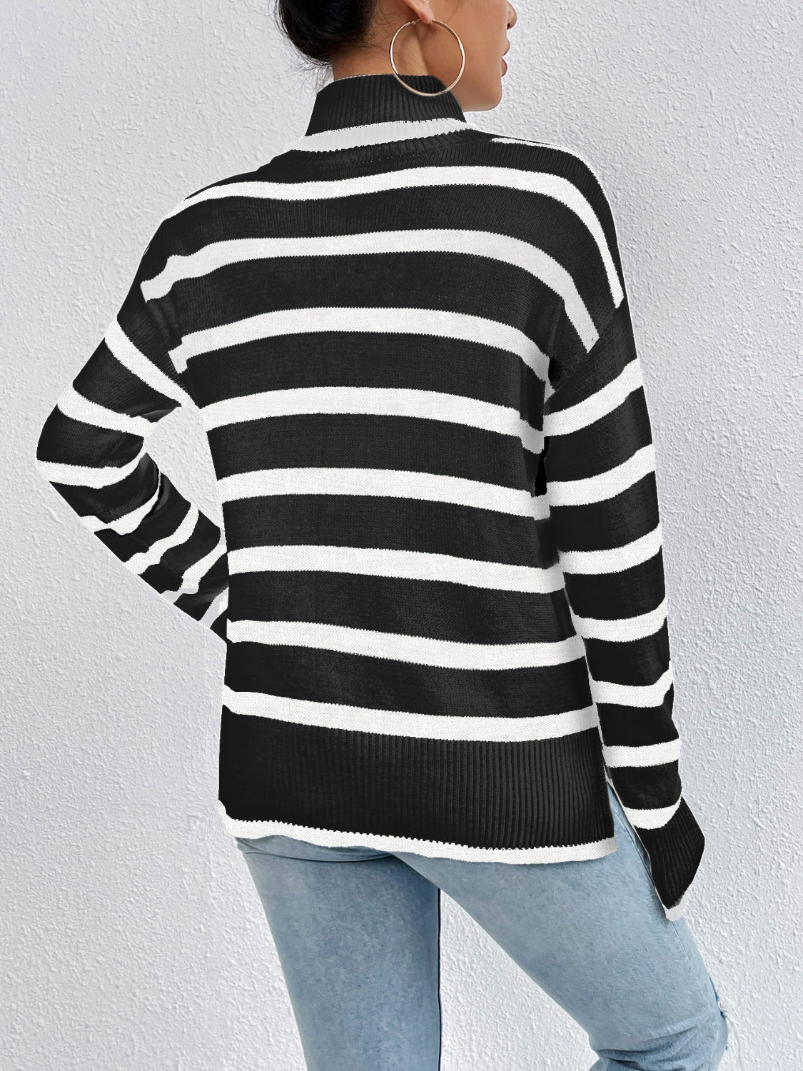 A stylish striped turtleneck drop shoulder sweater in soft fabric, showcasing its relaxed fit and trendy design.