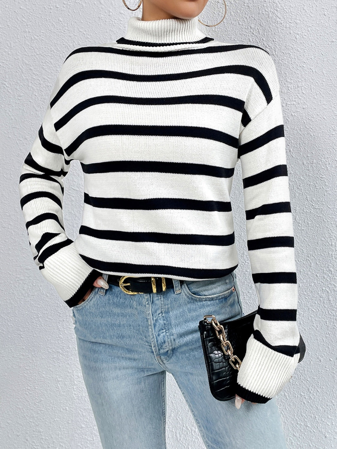 A stylish striped turtleneck drop shoulder sweater in soft fabric, showcasing its relaxed fit and trendy design.