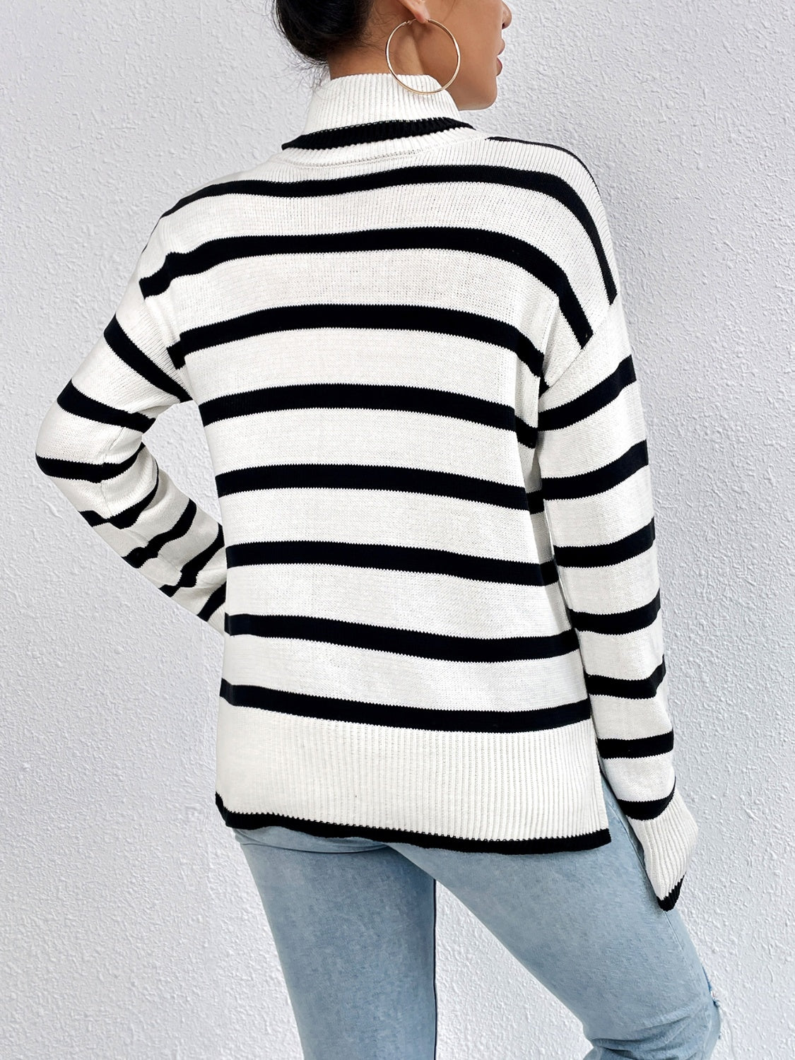 A stylish striped turtleneck drop shoulder sweater in soft fabric, showcasing its relaxed fit and trendy design.