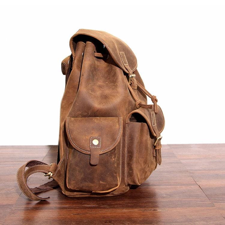 The Asmund Backpack, a genuine leather rucksack featuring a rugged design, adjustable straps, and multiple storage pockets, perfect for adventures.