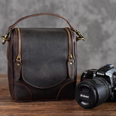 The Calista small leather camera bag made from full-grain leather, featuring a zippered back pocket and adjustable shoulder strap.