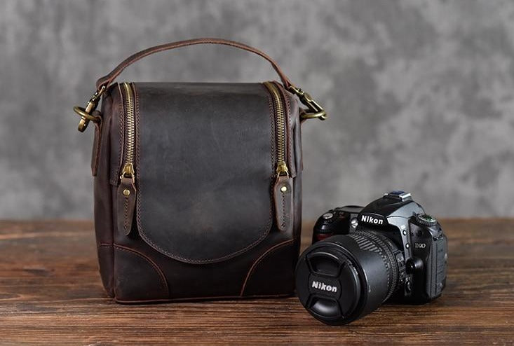 The Calista small leather camera bag made from full-grain leather, featuring a zippered back pocket and adjustable shoulder strap.