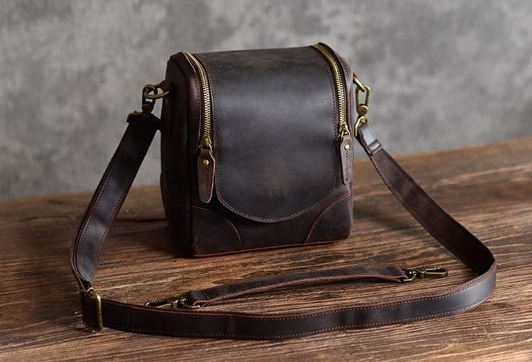 The Calista small leather camera bag made from full-grain leather, featuring a zippered back pocket and adjustable shoulder strap.