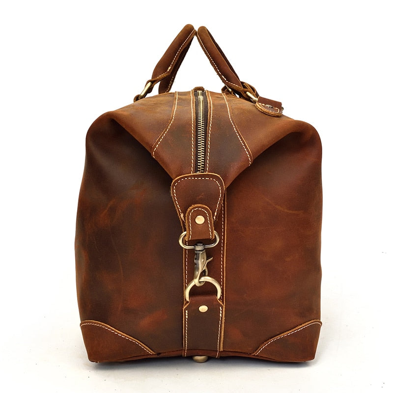 The Eira Duffle Bag made of premium crazy horse leather in two shades of brown, showcasing its spacious design and comfortable leather handles.