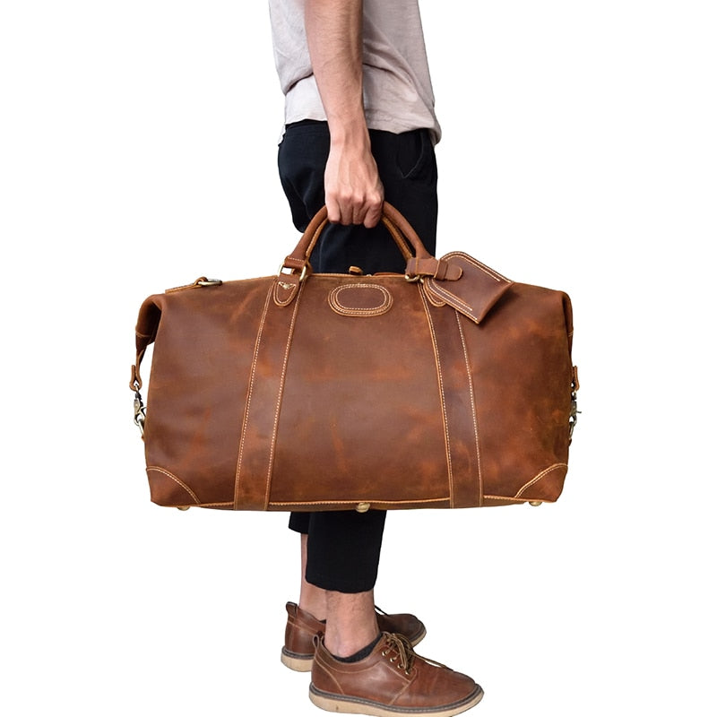 The Eira Duffle Bag made of premium crazy horse leather in two shades of brown, showcasing its spacious design and comfortable leather handles.