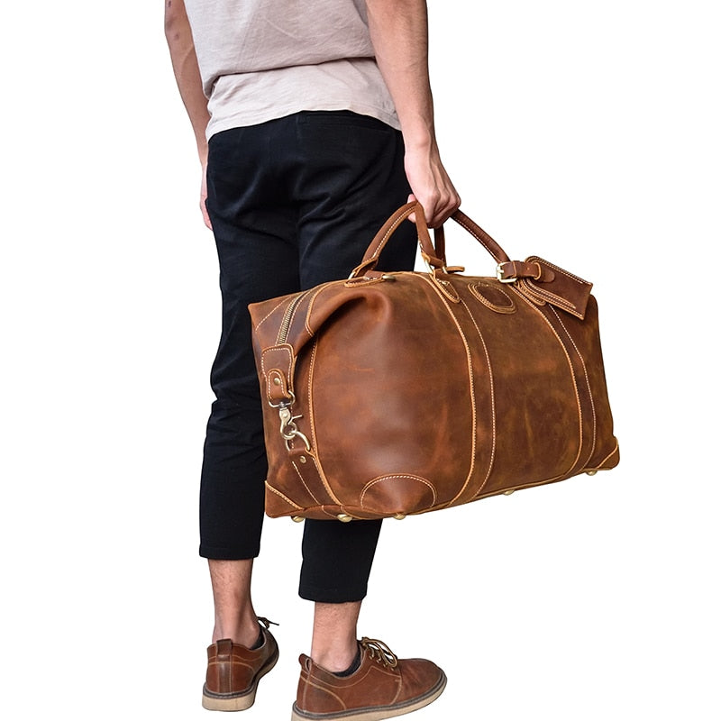 The Eira Duffle Bag made of premium crazy horse leather in two shades of brown, showcasing its spacious design and comfortable leather handles.