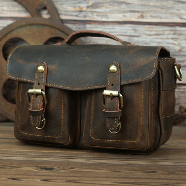 The Faust Leather Camera Bag, a handcrafted vintage-style crossbody bag made from full-grain leather, featuring exterior pockets and adjustable straps.