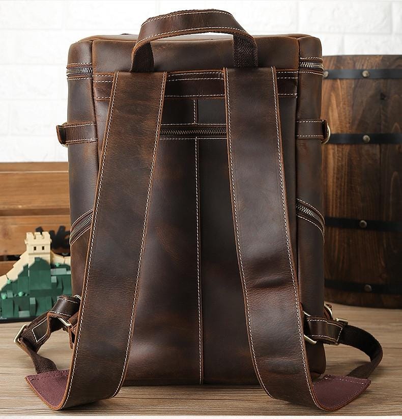 The Raoul Backpack, a handmade vintage leather backpack featuring multiple pockets and adjustable straps, showcasing its rustic charm and durability.