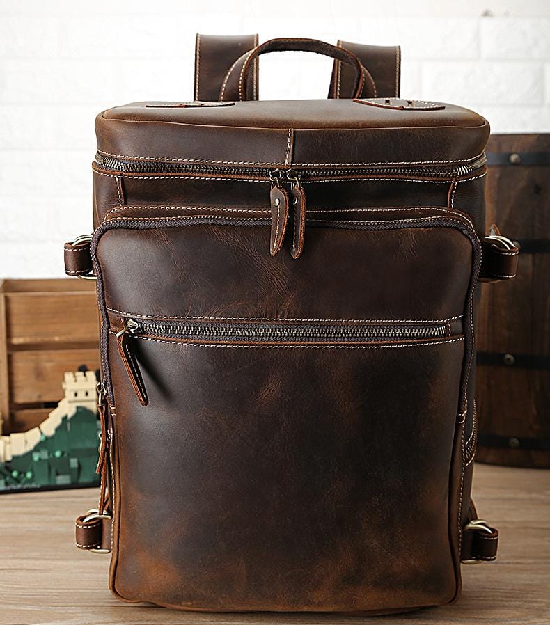 The Raoul Backpack, a handmade vintage leather backpack featuring multiple pockets and adjustable straps, showcasing its rustic charm and durability.