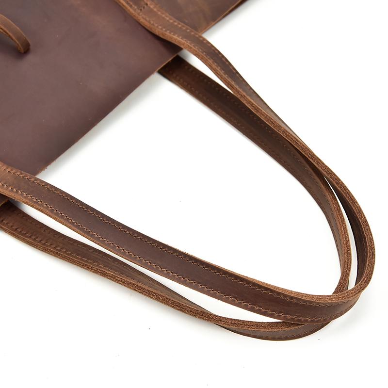 The Taavi Tote, a handcrafted leather tote bag, showcasing its unique crazy horse leather texture and spacious design.