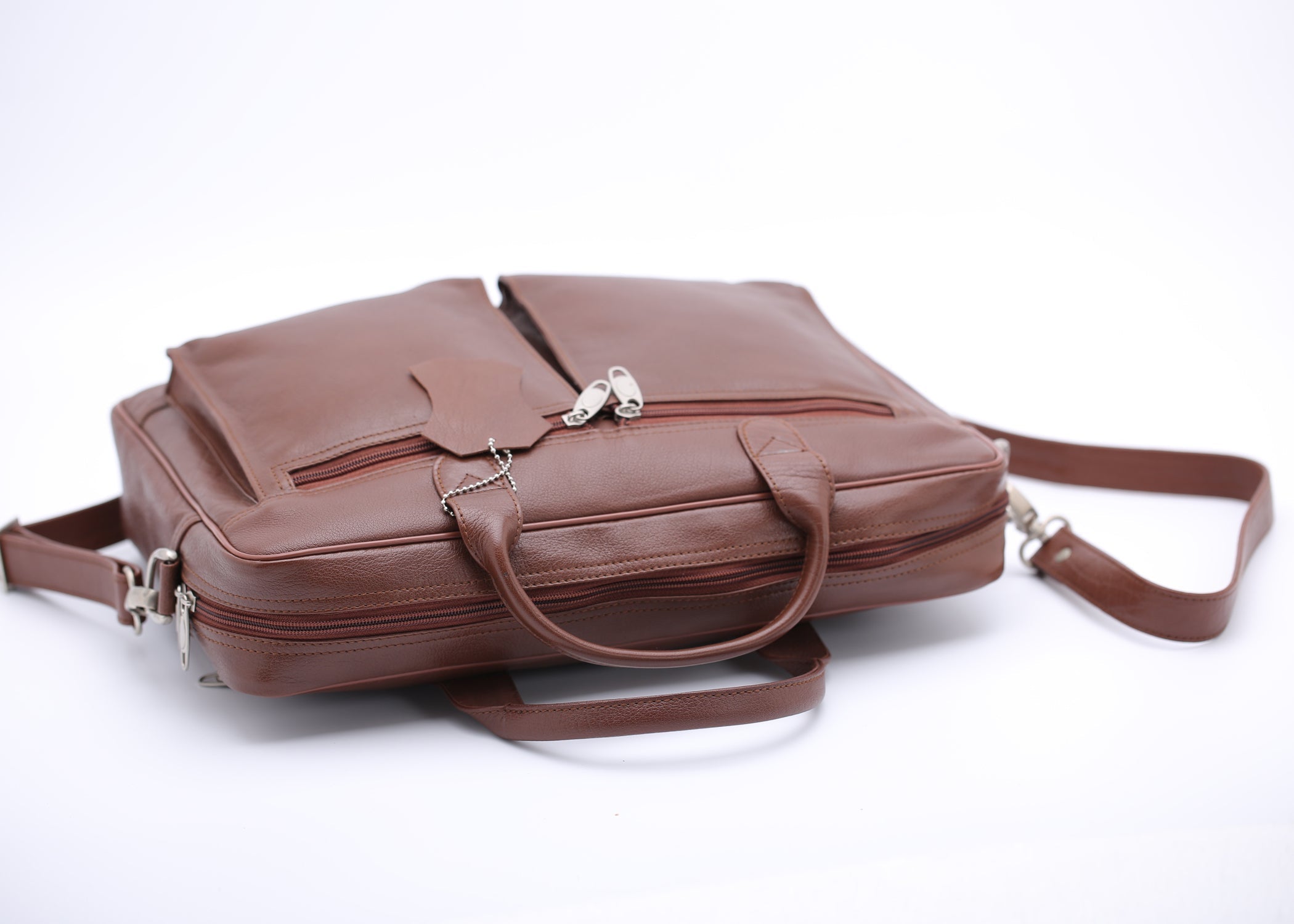Tan leather briefcase bag with multiple compartments and adjustable shoulder strap, designed for professionals.