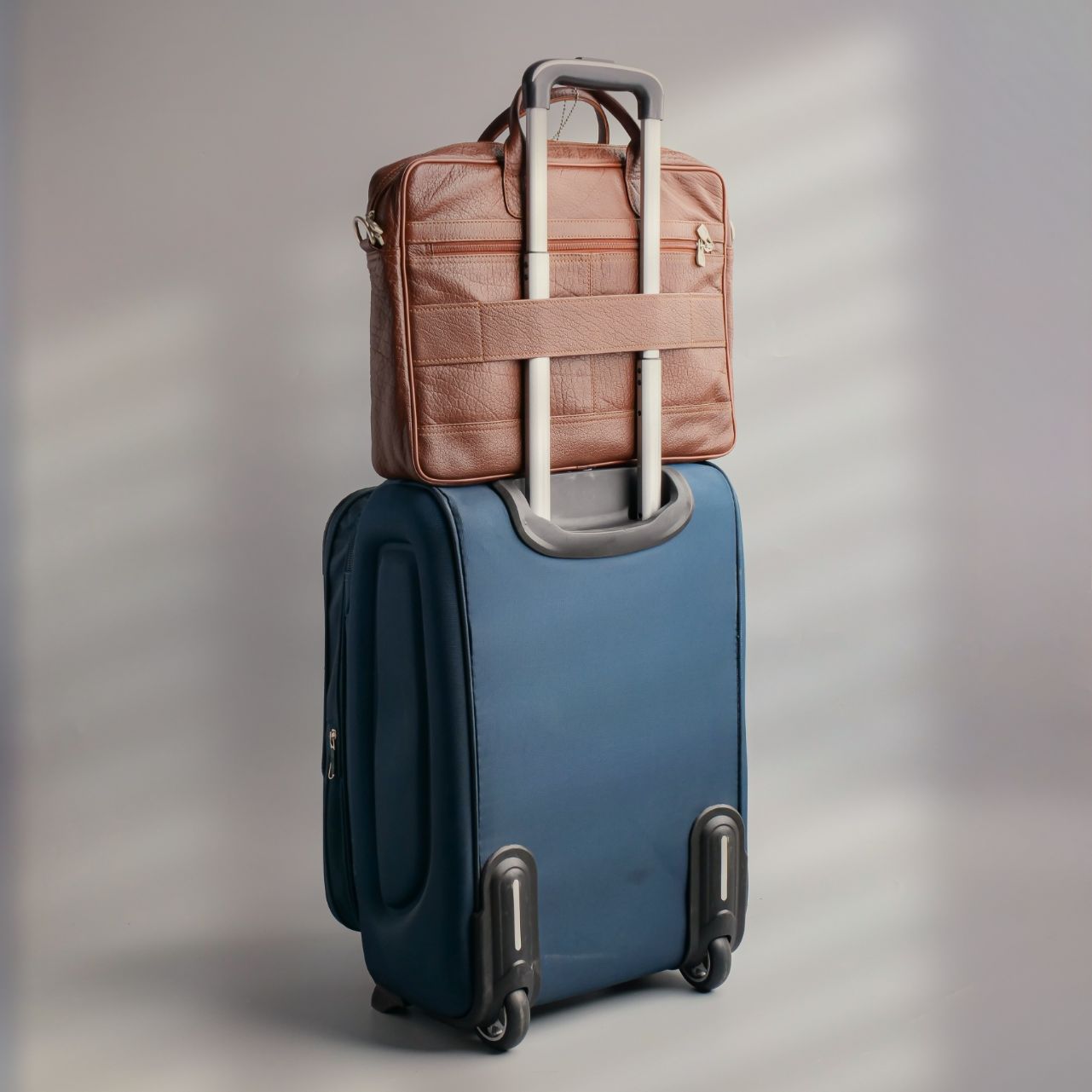 Tan leather briefcase bag with multiple compartments and adjustable shoulder strap, designed for professionals.