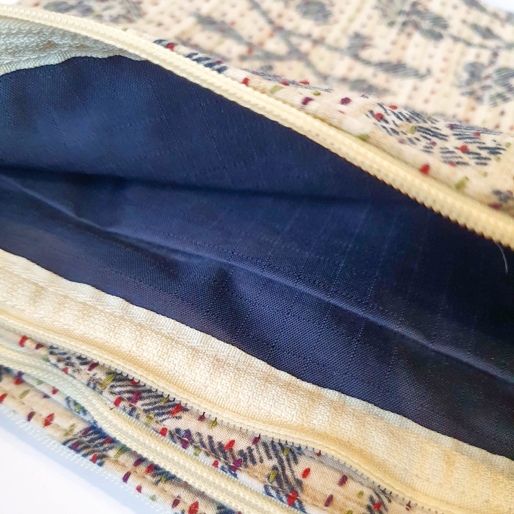 Upcycled sari clutch featuring vibrant colors and intricate kantha stitch embroidery, perfect for carrying essentials.