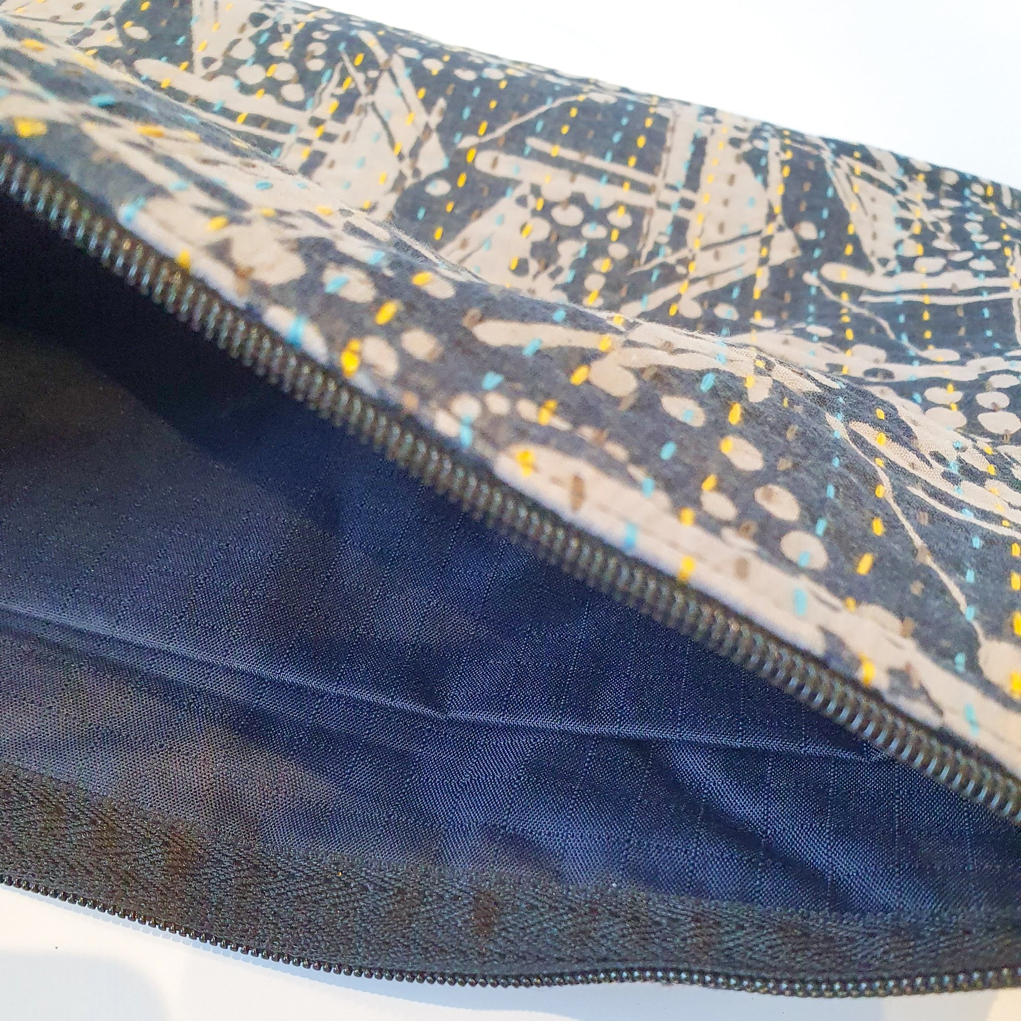 Upcycled sari clutch featuring vibrant colors and intricate kantha stitch embroidery, perfect for carrying essentials.