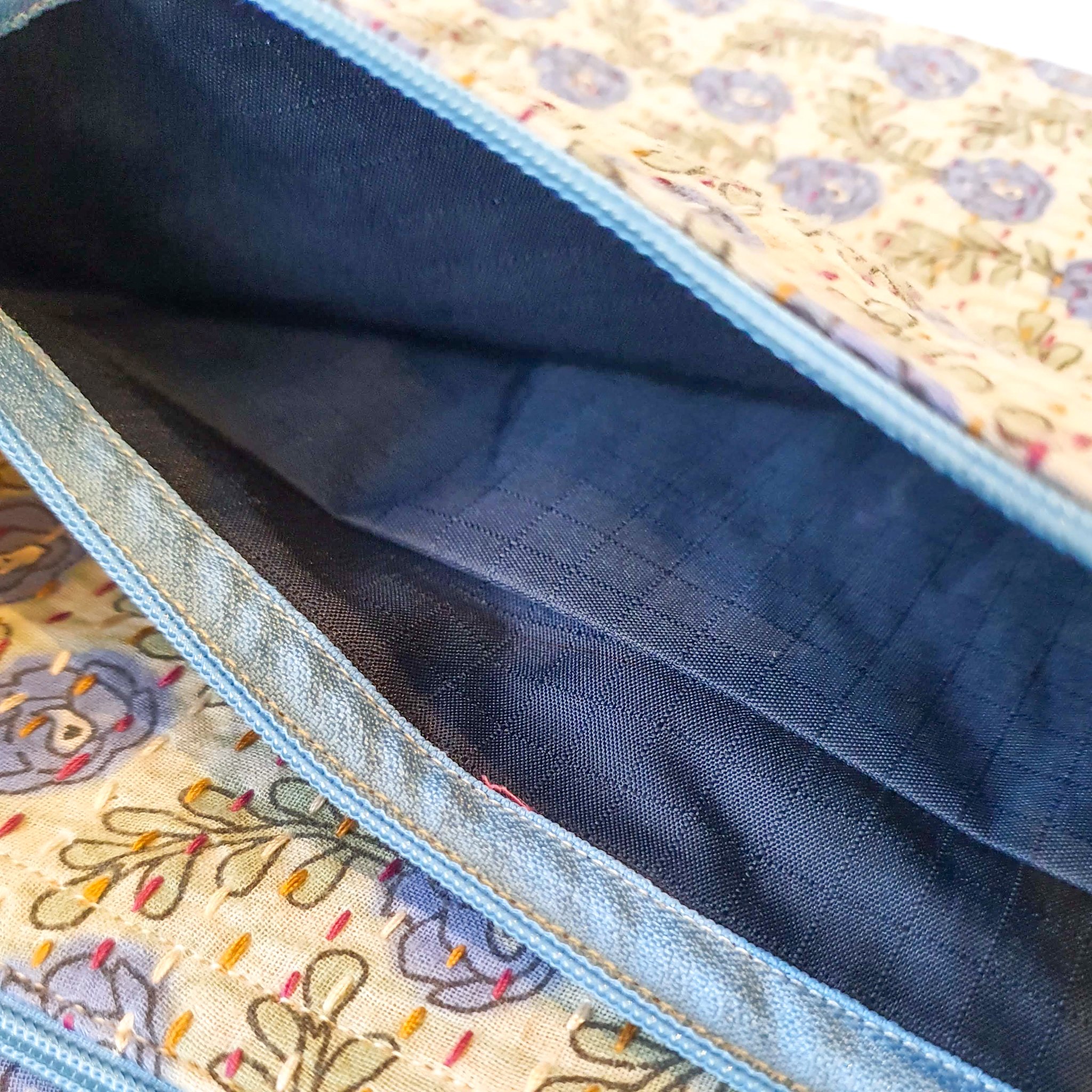 Upcycled sari clutch featuring vibrant colors and intricate kantha stitch embroidery, perfect for carrying essentials.