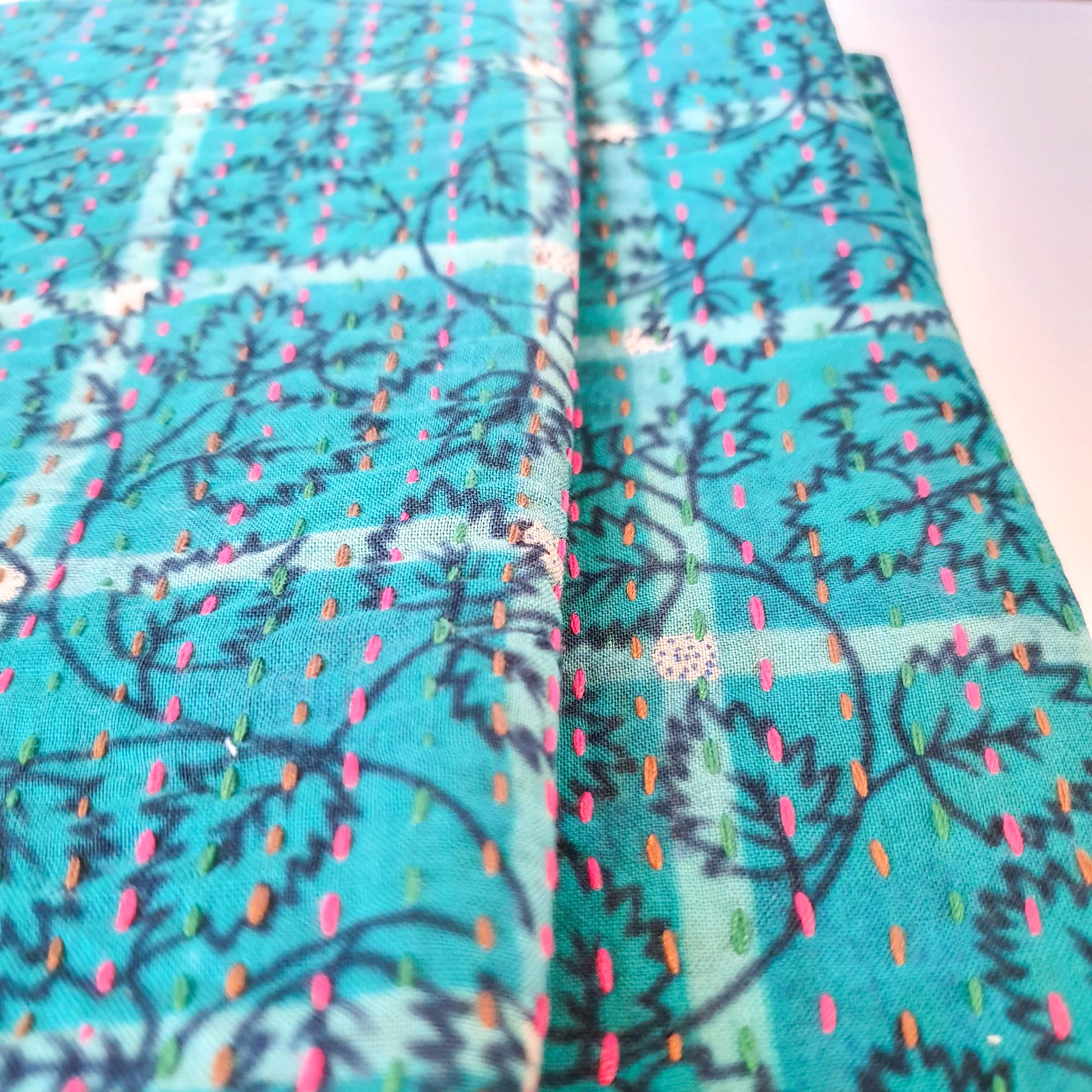 Upcycled sari clutch featuring vibrant colors and intricate kantha stitch embroidery, perfect for carrying essentials.