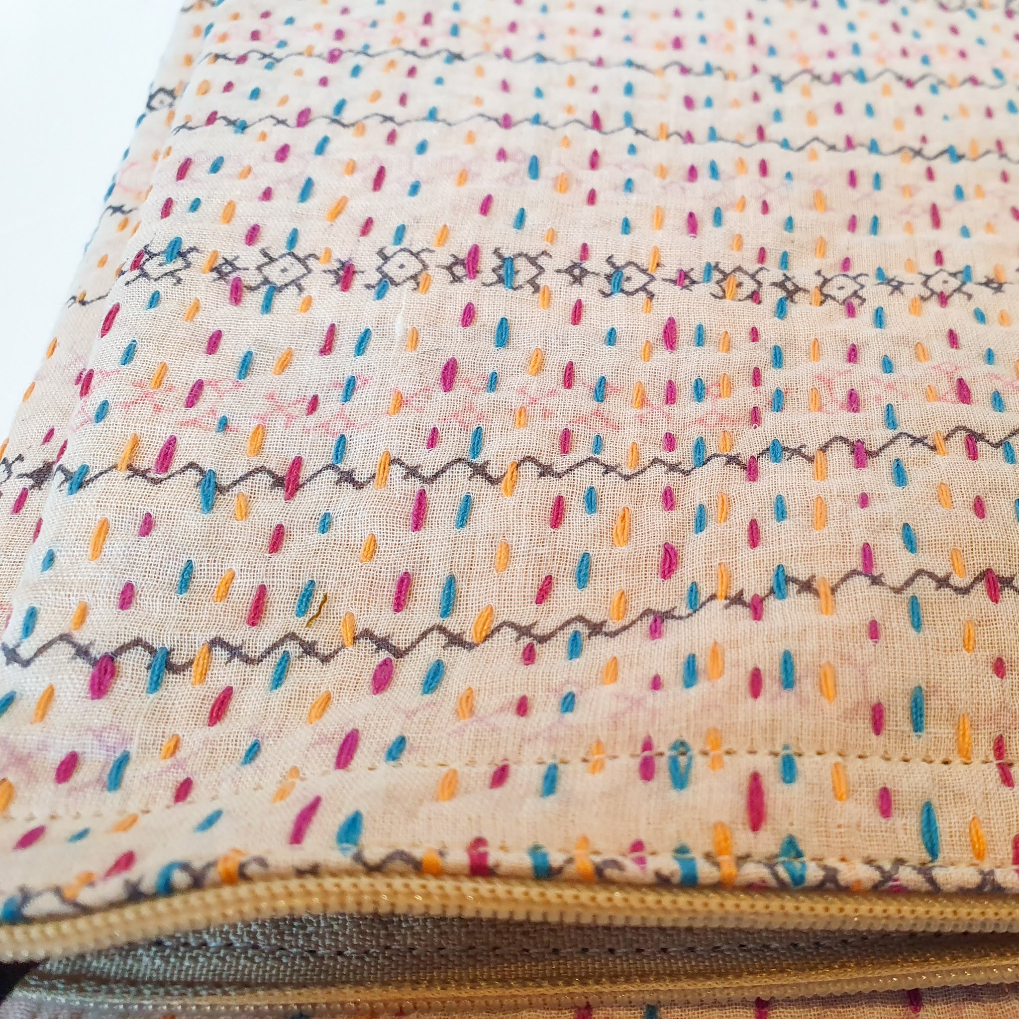 Upcycled sari clutch featuring vibrant colors and intricate kantha stitch embroidery, perfect for carrying essentials.