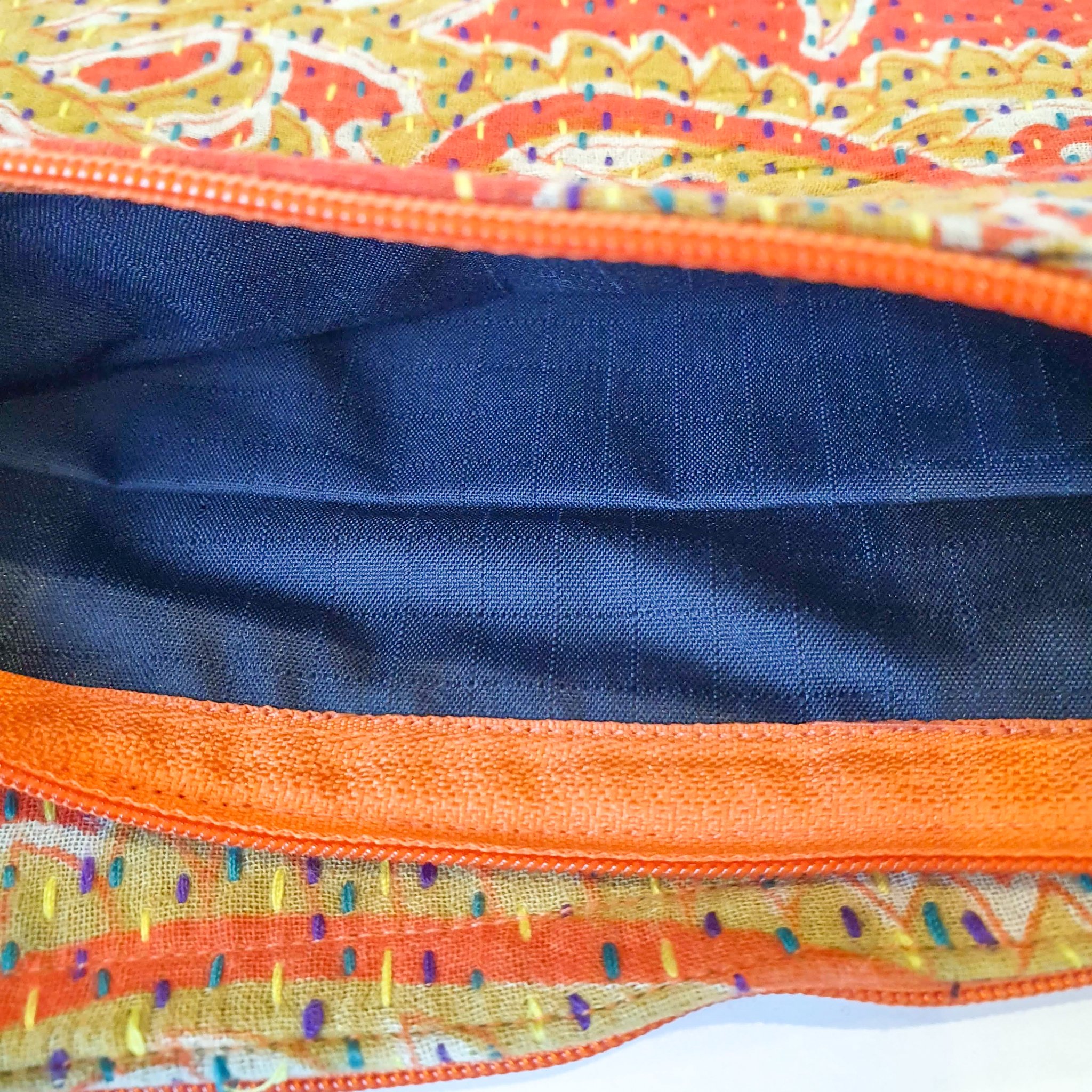 Upcycled sari clutch featuring vibrant colors and intricate kantha stitch embroidery, perfect for carrying essentials.