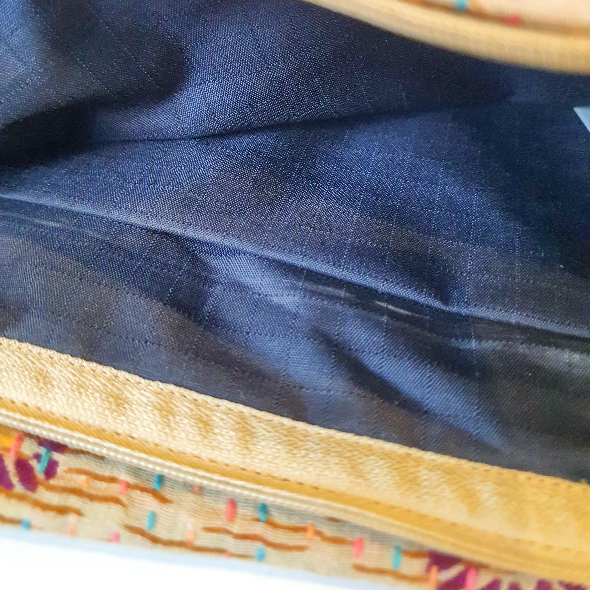 Upcycled sari clutch featuring vibrant colors and intricate kantha stitch embroidery, perfect for carrying essentials.