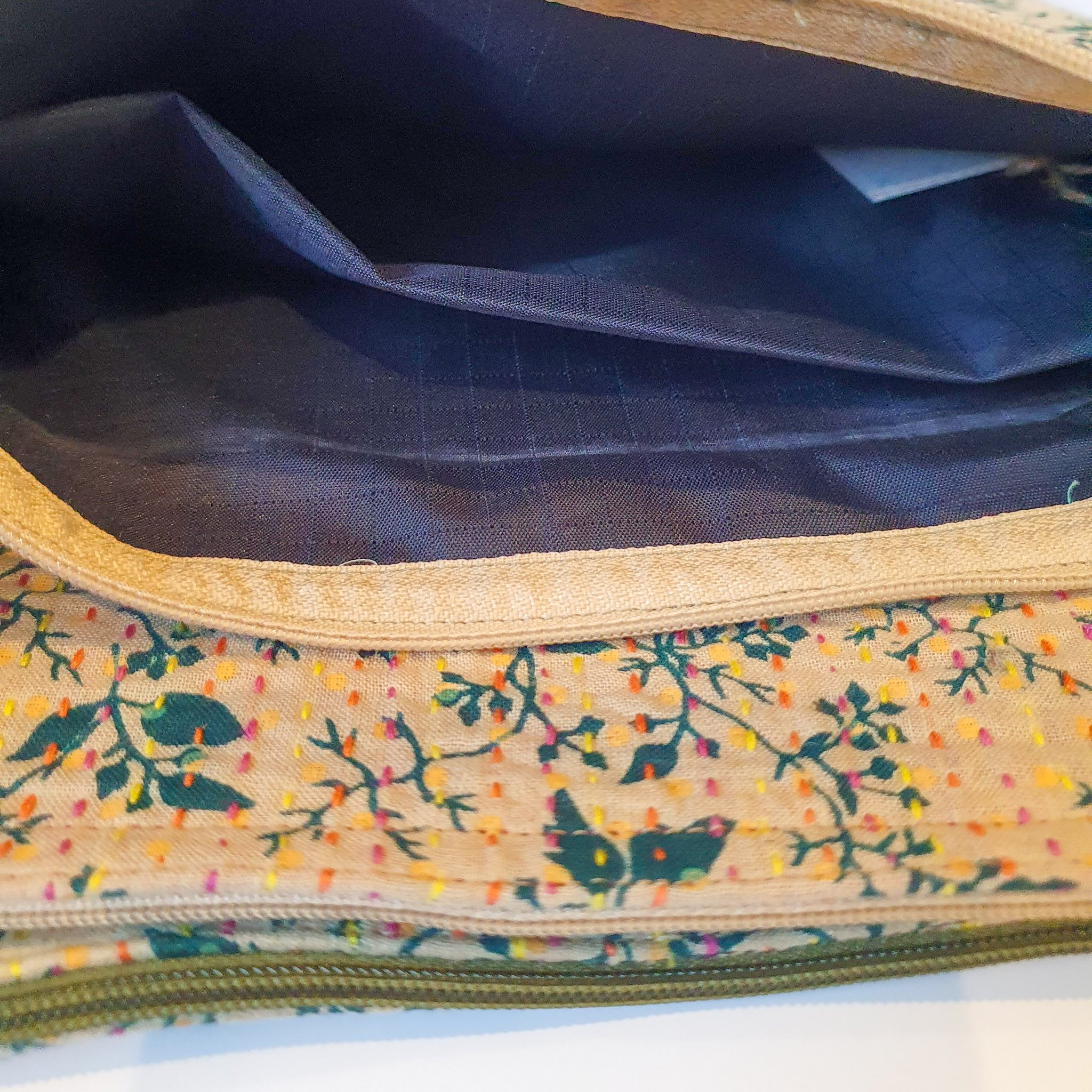 Upcycled sari clutch featuring vibrant colors and intricate kantha stitch embroidery, perfect for carrying essentials.
