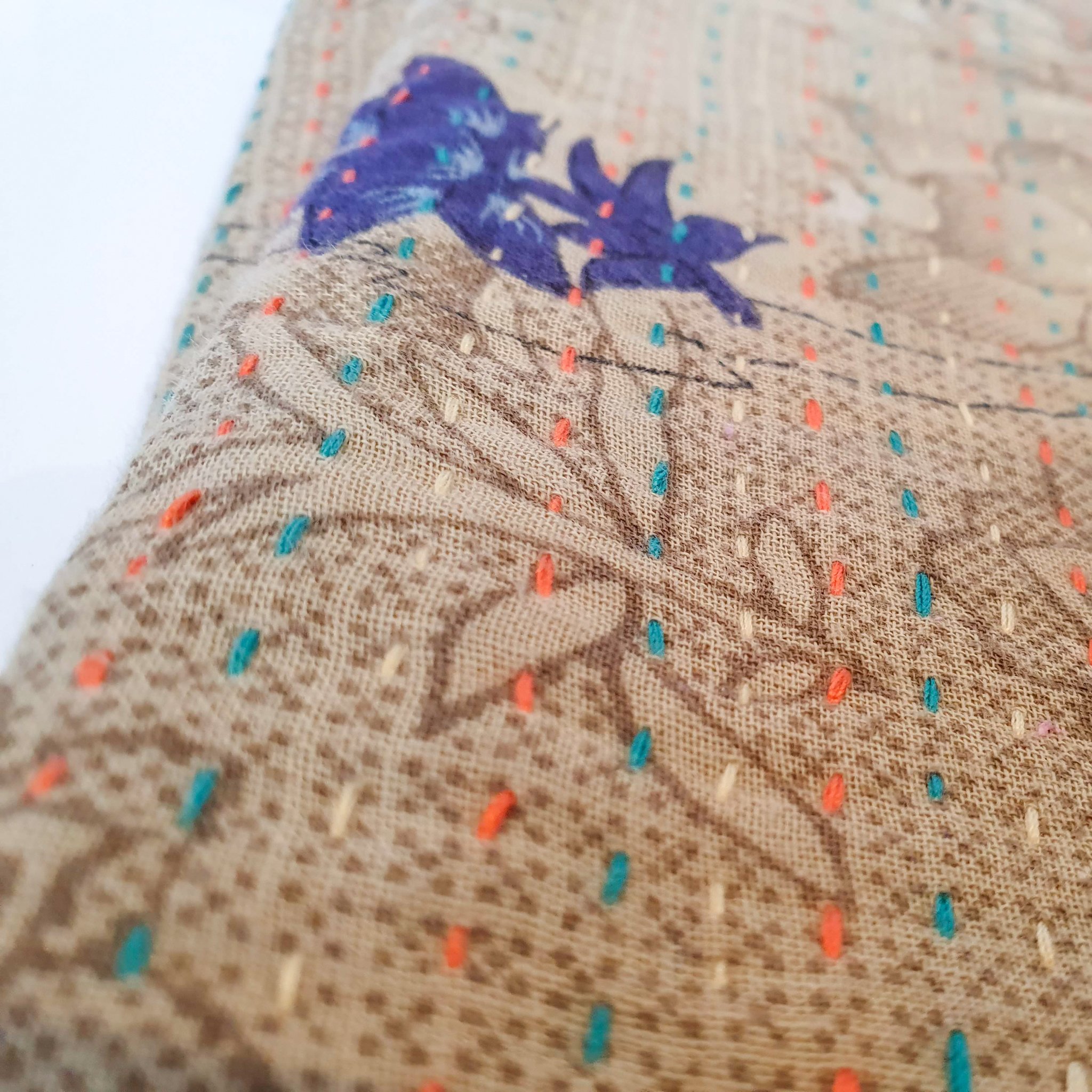 Upcycled sari clutch featuring vibrant colors and intricate kantha stitch embroidery, perfect for carrying essentials.