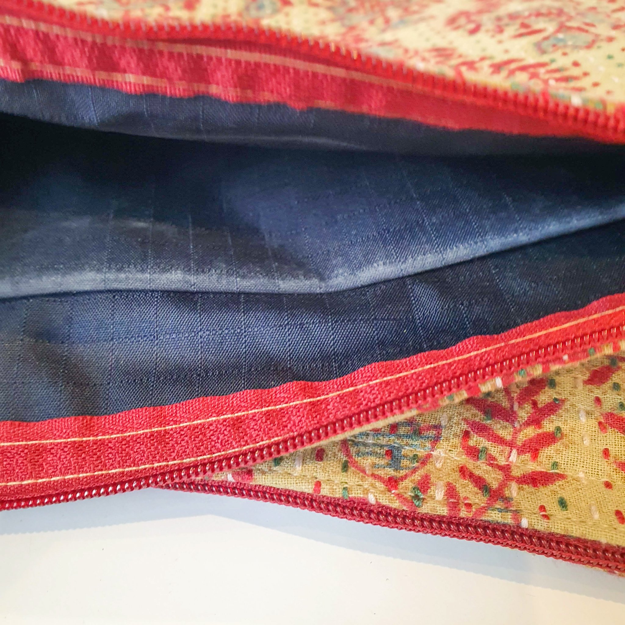 Upcycled sari clutch featuring vibrant colors and intricate kantha stitch embroidery, perfect for carrying essentials.