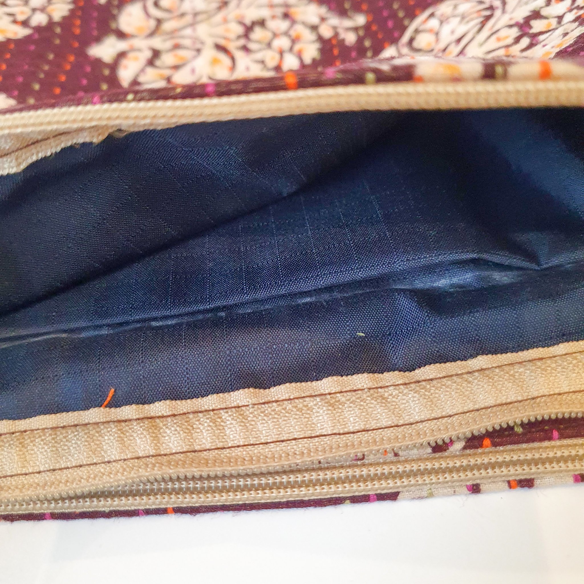 Upcycled sari clutch featuring vibrant colors and intricate kantha stitch embroidery, perfect for carrying essentials.