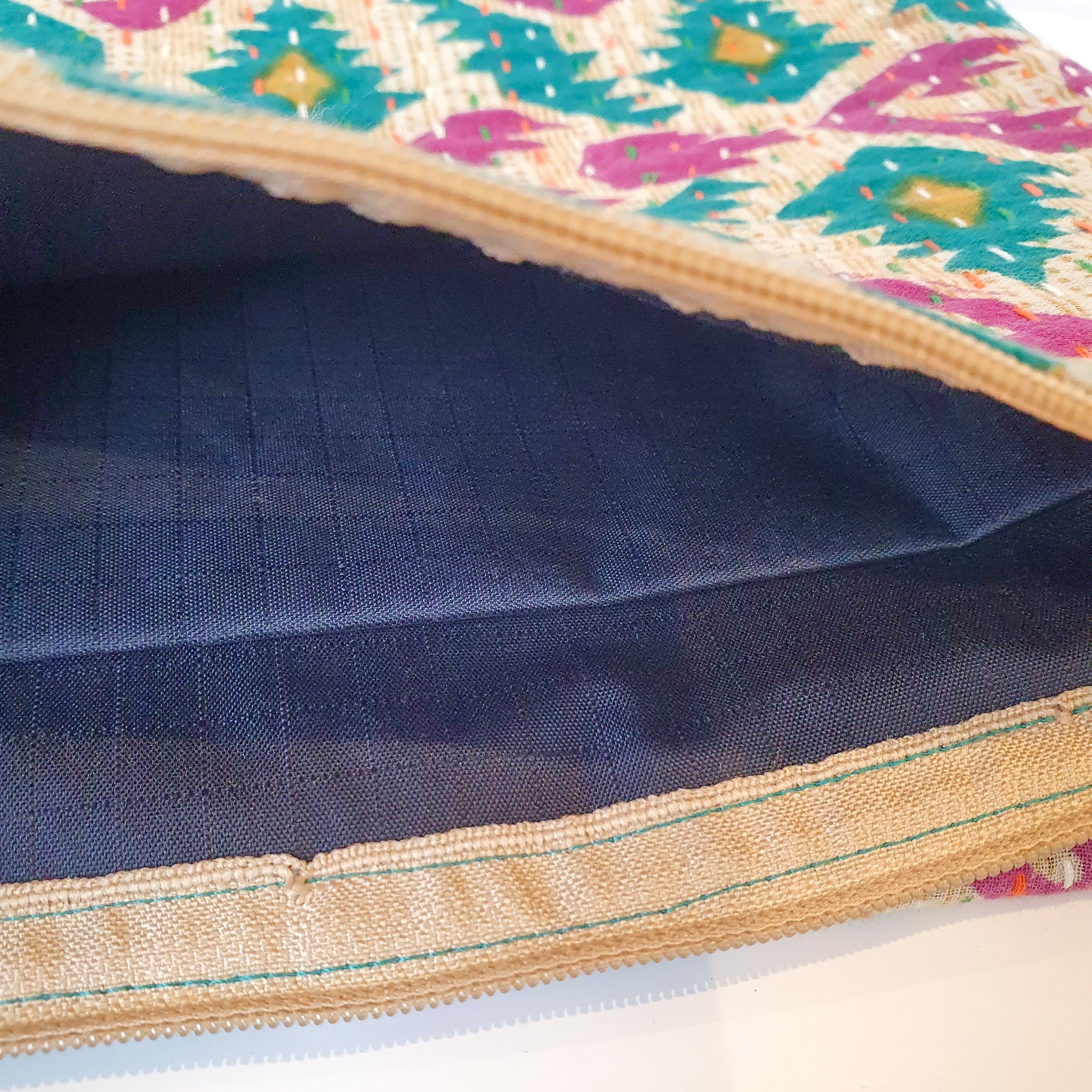 Upcycled sari clutch featuring vibrant colors and intricate kantha stitch embroidery, perfect for carrying essentials.