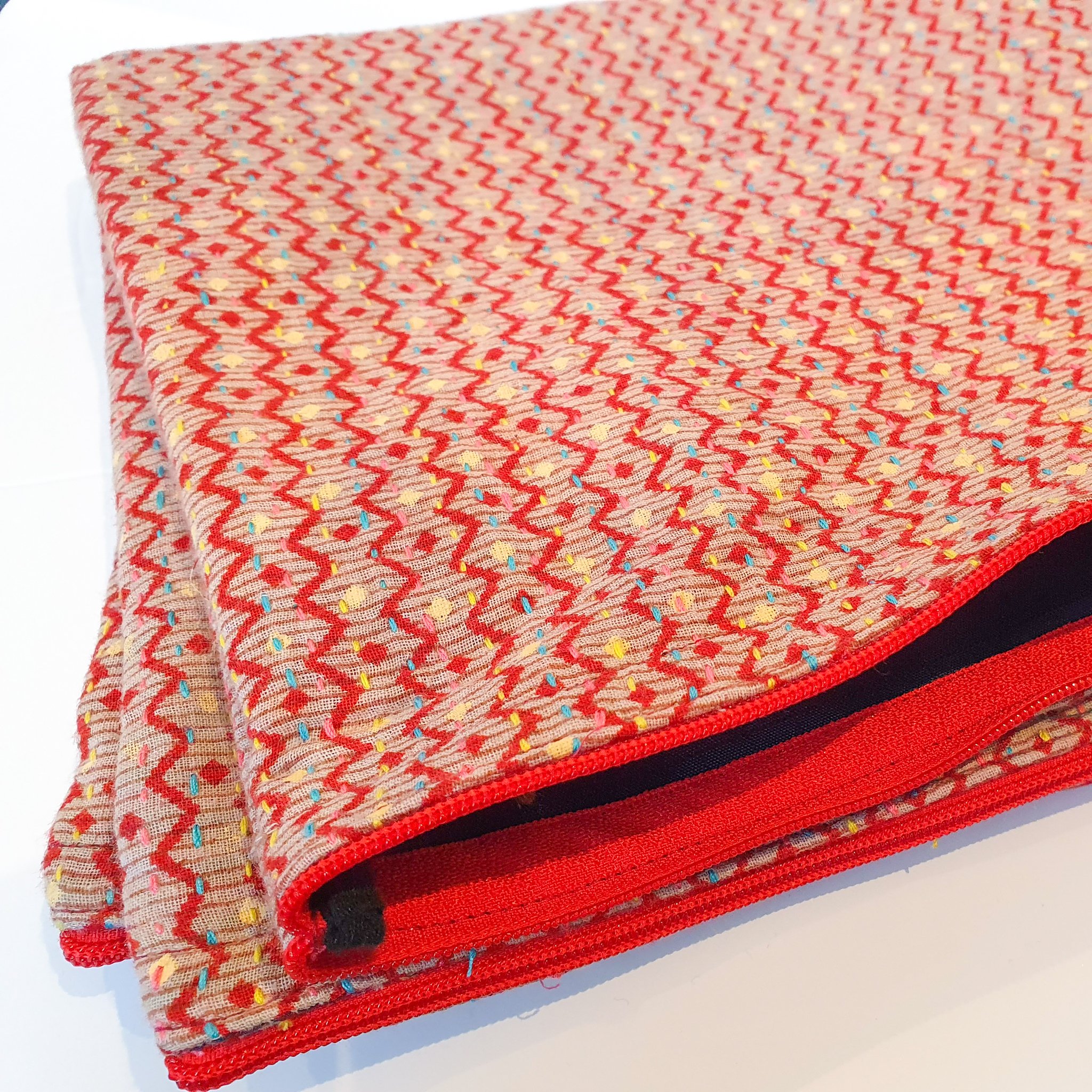 Upcycled sari clutch featuring vibrant colors and intricate kantha stitch embroidery, perfect for carrying essentials.