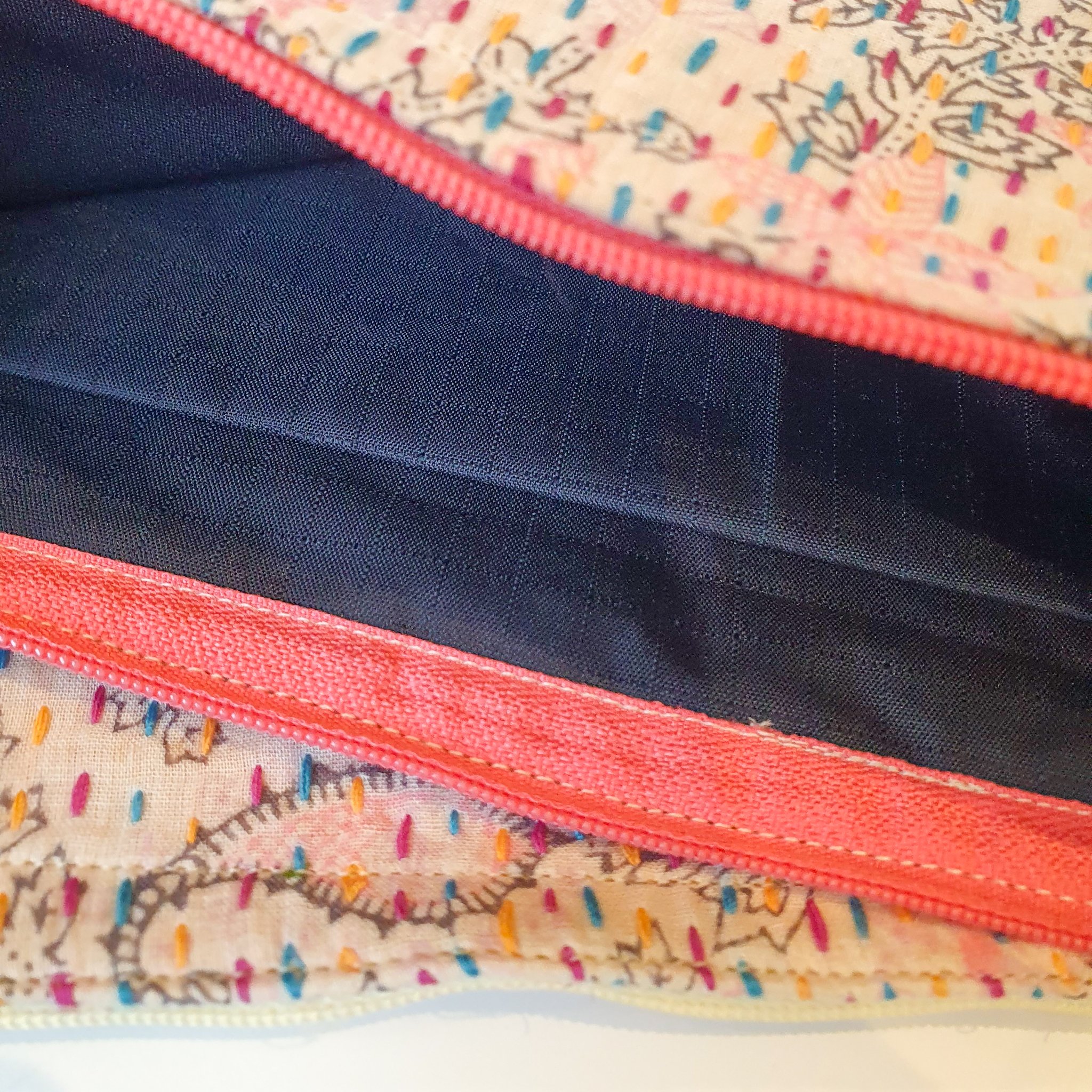 Upcycled sari clutch featuring vibrant colors and intricate kantha stitch embroidery, perfect for carrying essentials.
