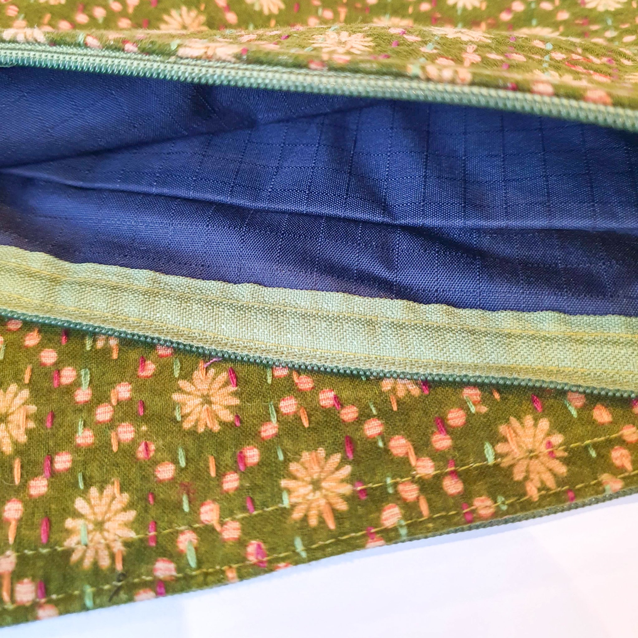 Upcycled sari clutch featuring vibrant colors and intricate kantha stitch embroidery, perfect for carrying essentials.