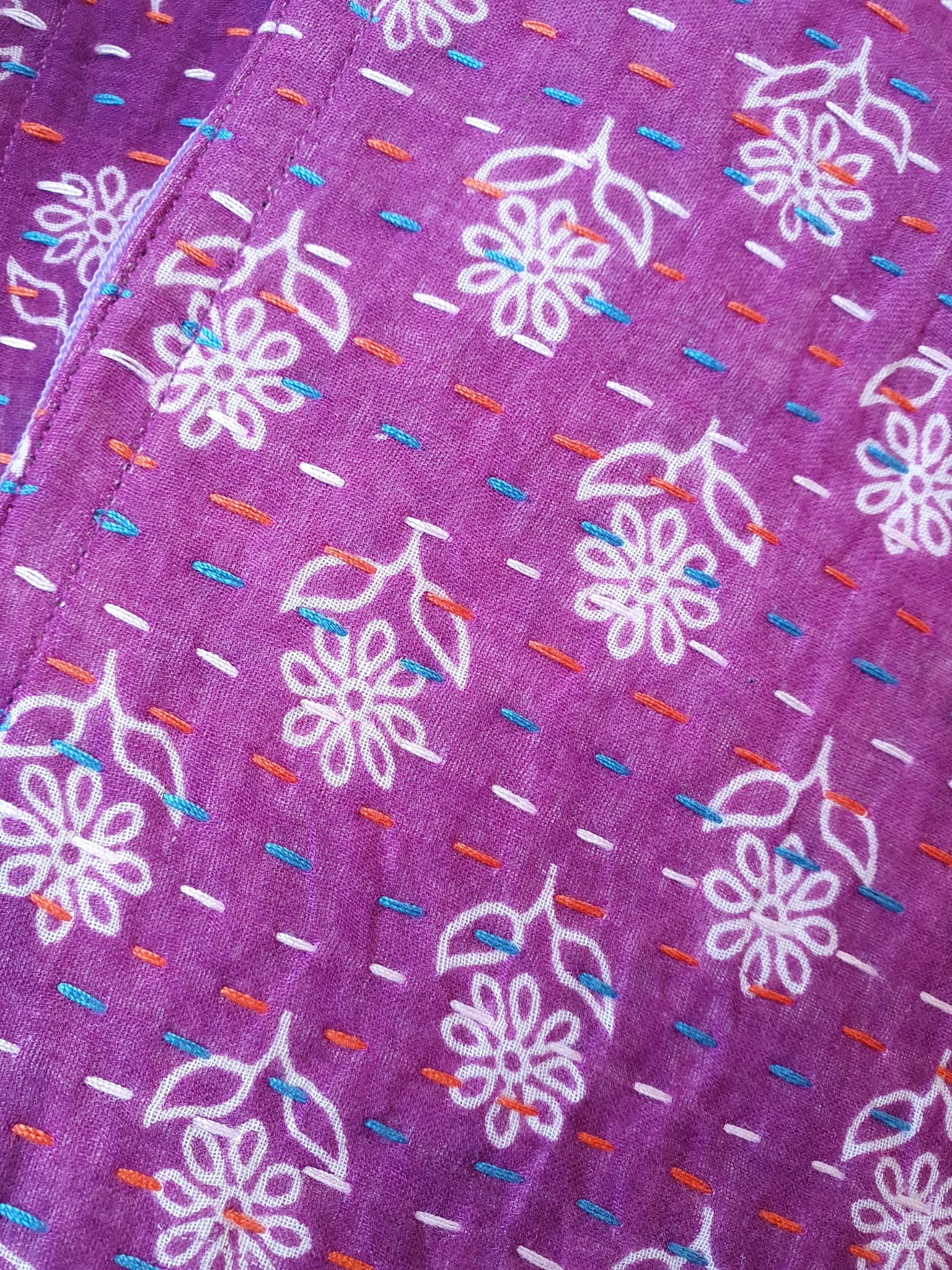 Upcycled sari clutch featuring vibrant colors and intricate kantha stitch embroidery, perfect for carrying essentials.