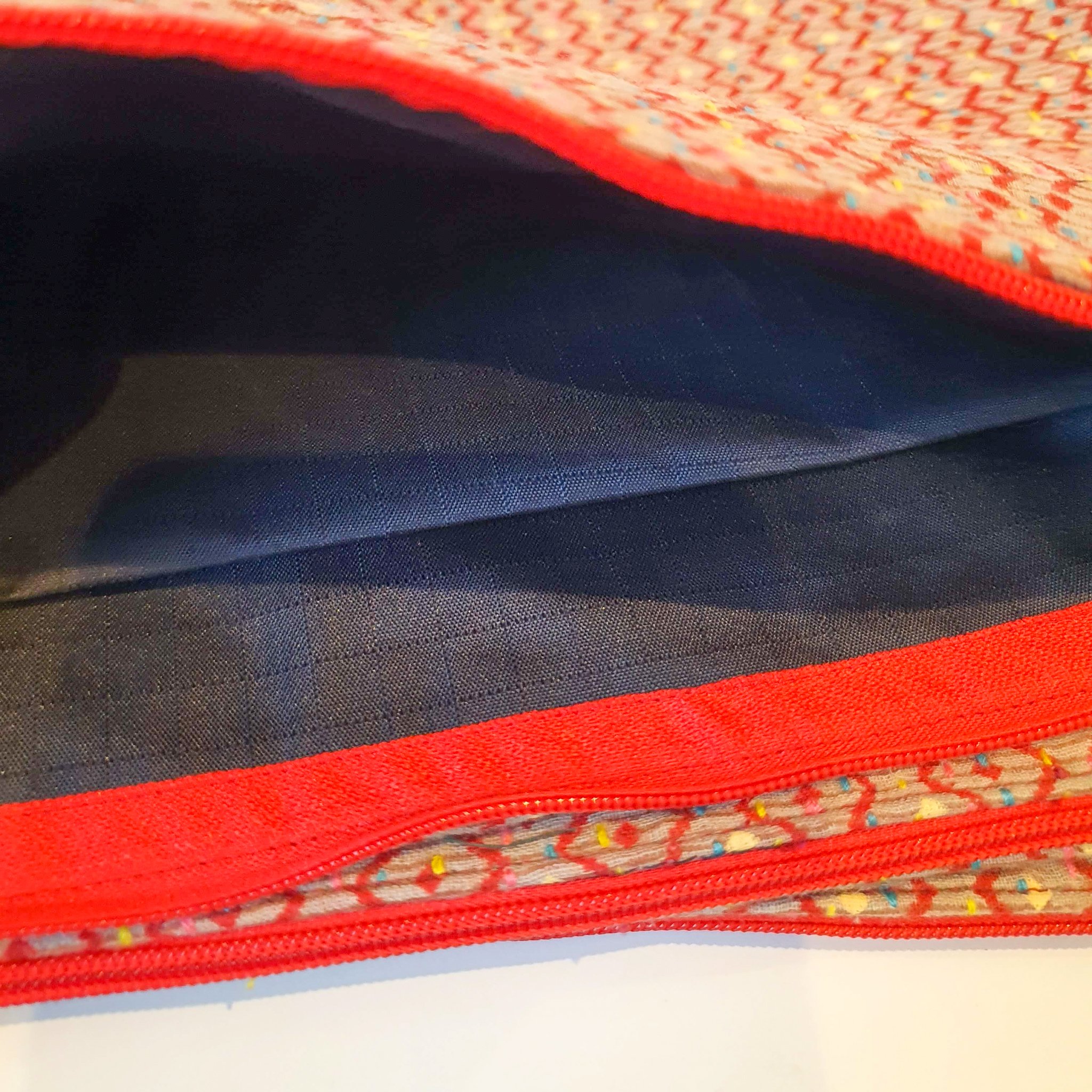 Upcycled sari clutch featuring vibrant colors and intricate kantha stitch embroidery, perfect for carrying essentials.