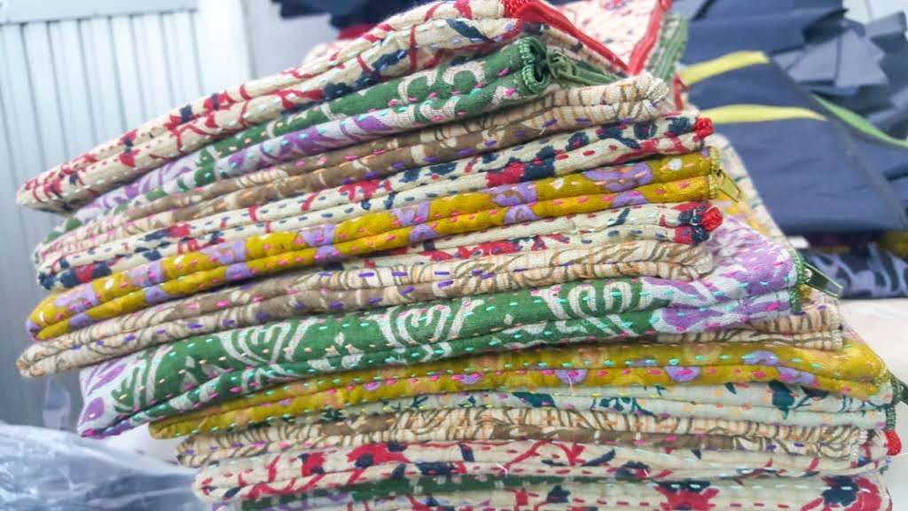 Upcycled sari clutch featuring vibrant colors and intricate kantha stitch embroidery, perfect for carrying essentials.