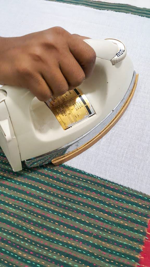 Upcycled sari clutch featuring vibrant colors and intricate kantha stitch embroidery, perfect for carrying essentials.