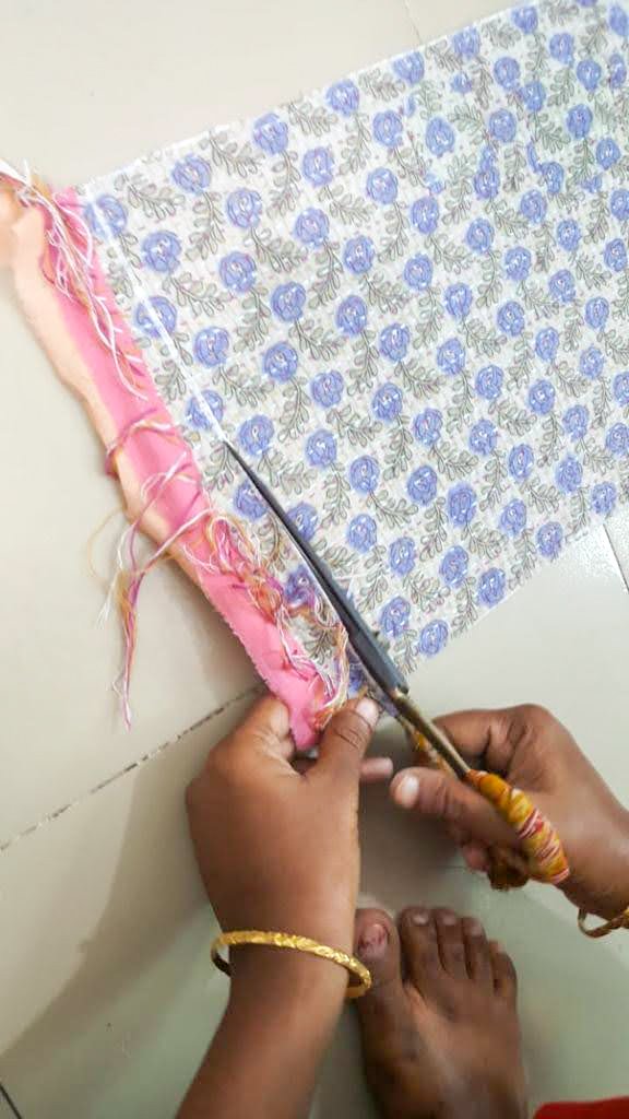 Upcycled sari clutch featuring vibrant colors and intricate kantha stitch embroidery, perfect for carrying essentials.