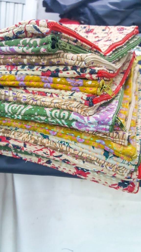 Upcycled sari clutch featuring vibrant colors and intricate kantha stitch embroidery, perfect for carrying essentials.